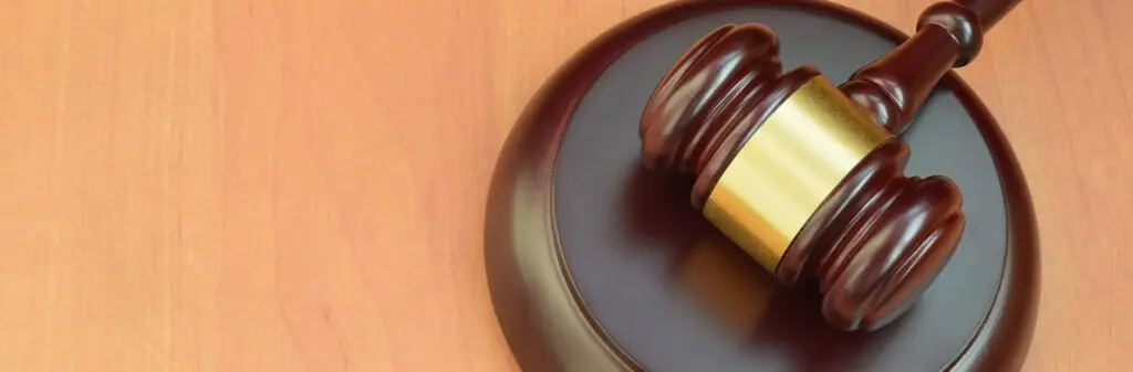 Justice mallet on wooden desk in a courtroom during a judicial trial